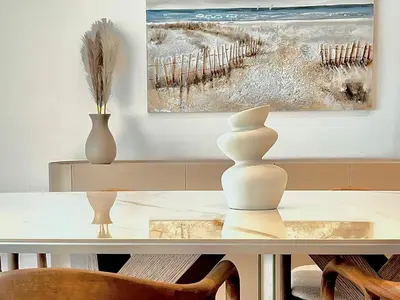 a table with two vases and a painting on the wall at Sealine Spacious Apartment in Athens