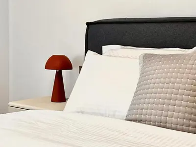 a bed with a red lamp on a side table at Sealine Spacious Apartment in Athens