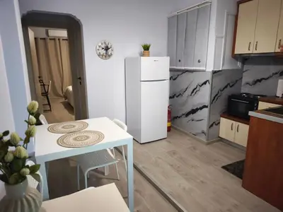 a kitchen with a white refrigerator and a table at Urban Piraeus Studio 200m from Neo Faliro Station in Piraeus