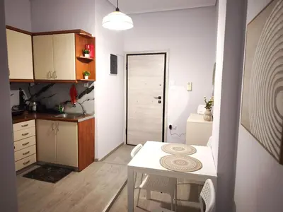 a small kitchen with a white table and a small room at Urban Piraeus Studio 200m from Neo Faliro Station in Piraeus