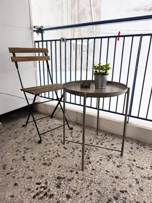 a chair and a table with a potted plant on a balcony at Urban Piraeus Studio 200m from Neo Faliro Station in Piraeus