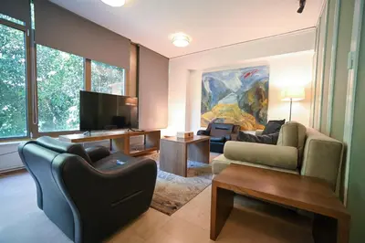 a living room with two couches and a tv at Tsakalof Luxe by Zeus Suites in Athens