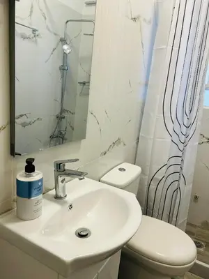 a bathroom with a sink and a toilet and a mirror at Metro blue line Megaro Mousikis Αpartment in Athens