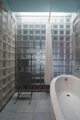 a bathroom with a chair and a bath tub at The 'it' Pagrati Hideout in Athens