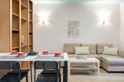 a living room with a couch and a table and chairs at The 'it' Pagrati Hideout in Athens
