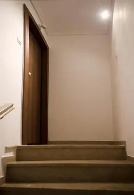 a wooden door in a room with stairs at Best House Erato Neo Faliro Piraeus in Piraeus