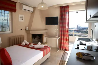 a bedroom with a bed and a fireplace and a television at Best House Erato Neo Faliro Piraeus in Piraeus