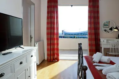 a living room with a tv and a large window at Best House Penelope Neo Faliro Piraeus in Piraeus