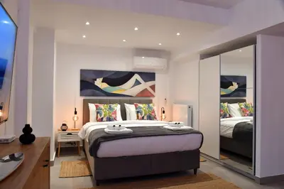 a bedroom with a large bed and a mirror at Hidden Paradise at Kolonaki in Athens