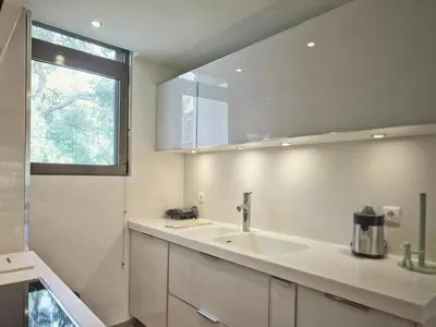 a white kitchen with a sink and a window at Sea Breeze near Vouliagmeni in Athens