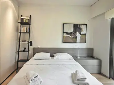 a bedroom with a large white bed with two towels at Sea Breeze near Vouliagmeni in Athens