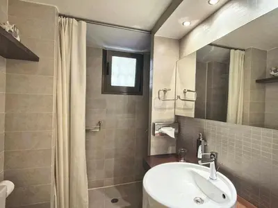a bathroom with a sink and a toilet and a mirror at Sea Breeze near Vouliagmeni in Athens