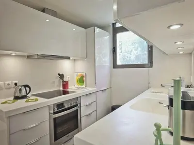 a kitchen with white cabinets and a sink and a window at Sea Breeze near Vouliagmeni in Athens