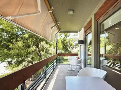 a balcony with a white table and chairs on it at Sea Breeze near Vouliagmeni in Athens