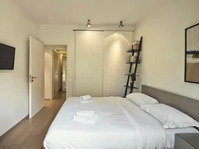 a bedroom with a large white bed with two towels on it at Sea Breeze near Vouliagmeni in Athens