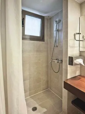 a bathroom with a shower with a shower curtain at Sea Breeze near Vouliagmeni in Athens