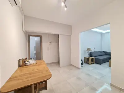 a living room with a table and a couch at Family apartment at the center of Piraeus in Piraeus