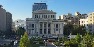 a large white building in the middle of a city at Family apartment at the center of Piraeus in Piraeus