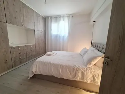 a bedroom with a white bed and a window at Family apartment at the center of Piraeus in Piraeus