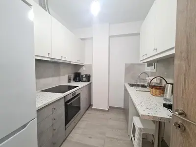 a white kitchen with white cabinets and a sink at Family apartment at the center of Piraeus in Piraeus