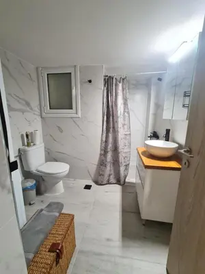a white bathroom with a sink and a toilet at Family apartment at the center of Piraeus in Piraeus