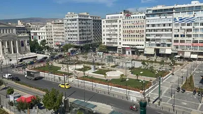 a city with tall buildings and a street with cars at Family apartment at the center of Piraeus in Piraeus