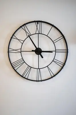 a black and white clock on a white wall at Nea Smyrni 1 BDRM - Links To City Center by ΜΡS in Athens