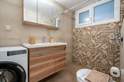 a bathroom with a washing machine and a washer and dryer at Nea Smyrni 1 BDRM - Links To City Center by ΜΡS in Athens