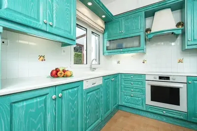 a blue kitchen with a bowl of fruit on the counter at Casa Marina in Porto Rafti