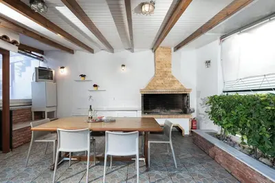 a kitchen with a wooden table and a fireplace at Casa Marina in Porto Rafti
