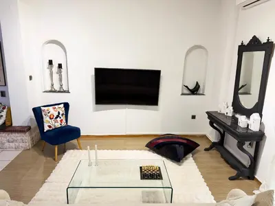 a living room with a tv and a glass table at Felicias Cozy Exarchia Apartment Pet Friendly in Athens