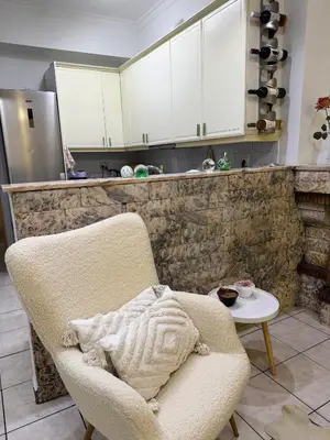 a living room with a chair and a table at Felicias Cozy Exarchia Apartment Pet Friendly in Athens