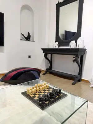 a chess board on a glass table in front of a mirror at Felicias Cozy Exarchia Apartment Pet Friendly in Athens