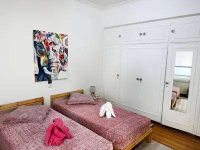 two beds in a bedroom with two pink towels at Felicias Cozy Exarchia Apartment Pet Friendly in Athens