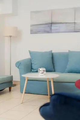 a living room with a blue couch and a coffee table at Livingstone House in Porto Rafti
