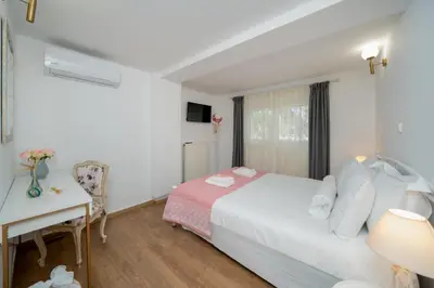 a bedroom with a bed and a desk and a window at Livingstone House in Porto Rafti