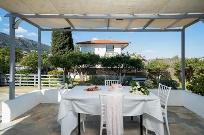 a white table and chairs on a patio at Livingstone House in Porto Rafti