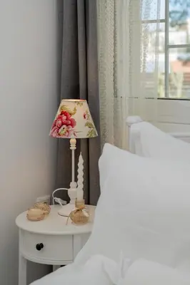 a lamp sitting on a table next to a bed at Livingstone House in Porto Rafti