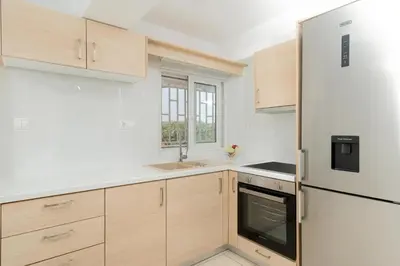 a kitchen with wooden cabinets and a refrigerator at Livingstone House in Porto Rafti