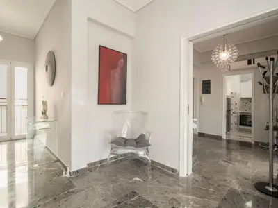 a living room with a chair and a chandelier at Apartment Athen von unserem Haus aus- wenige Schritte von der Akropolis entfernt by Interhome in Athens