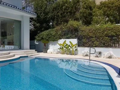 a swimming pool with chairs next to a house at Holiday Home Villa Stefani mit privatem Pool by Interhome in Athens