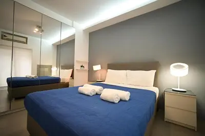 a bedroom with a blue bed with towels on it at Kolonaki Urban Gem by Zeus Suites in Athens