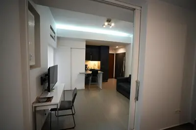 a living room with a desk and a television in a room at Kolonaki Urban Gem by Zeus Suites in Athens