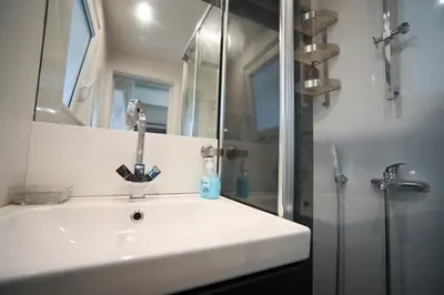 a bathroom with a white sink and a shower at Kolonaki Urban Gem by Zeus Suites in Athens