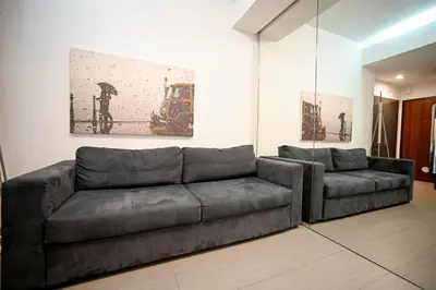 a living room with a couch and a painting at Kolonaki Urban Gem by Zeus Suites in Athens
