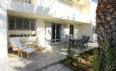 a patio with chairs and a table and a building at Apartment Theros near the beach in Anavissos