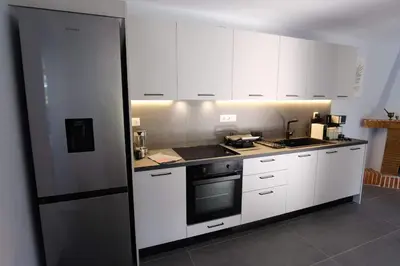 a kitchen with white cabinets and a stove top oven at Apartment Theros near the beach in Anavissos