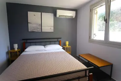 a bedroom with a bed and a window at Apartment Theros near the beach in Anavissos