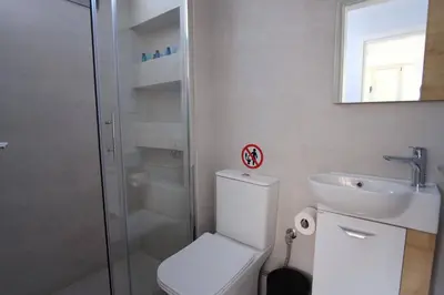 a bathroom with a toilet and a sink and a shower at Apartment Theros near the beach in Anavissos