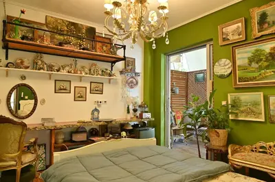 a bedroom with green walls and a bed and a chandelier at My House of Inspiration in Athens by the sea in Athens